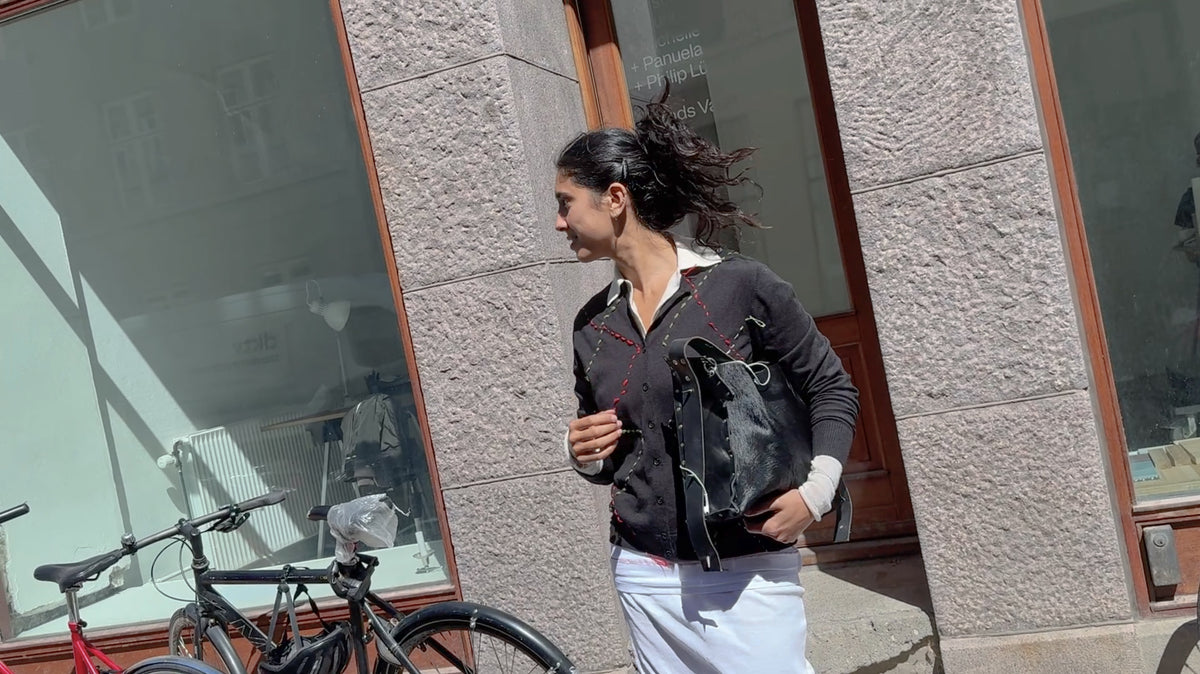 Model in an upcycled black knit cardigan on a Copenhagen street – RE;INCARNATED